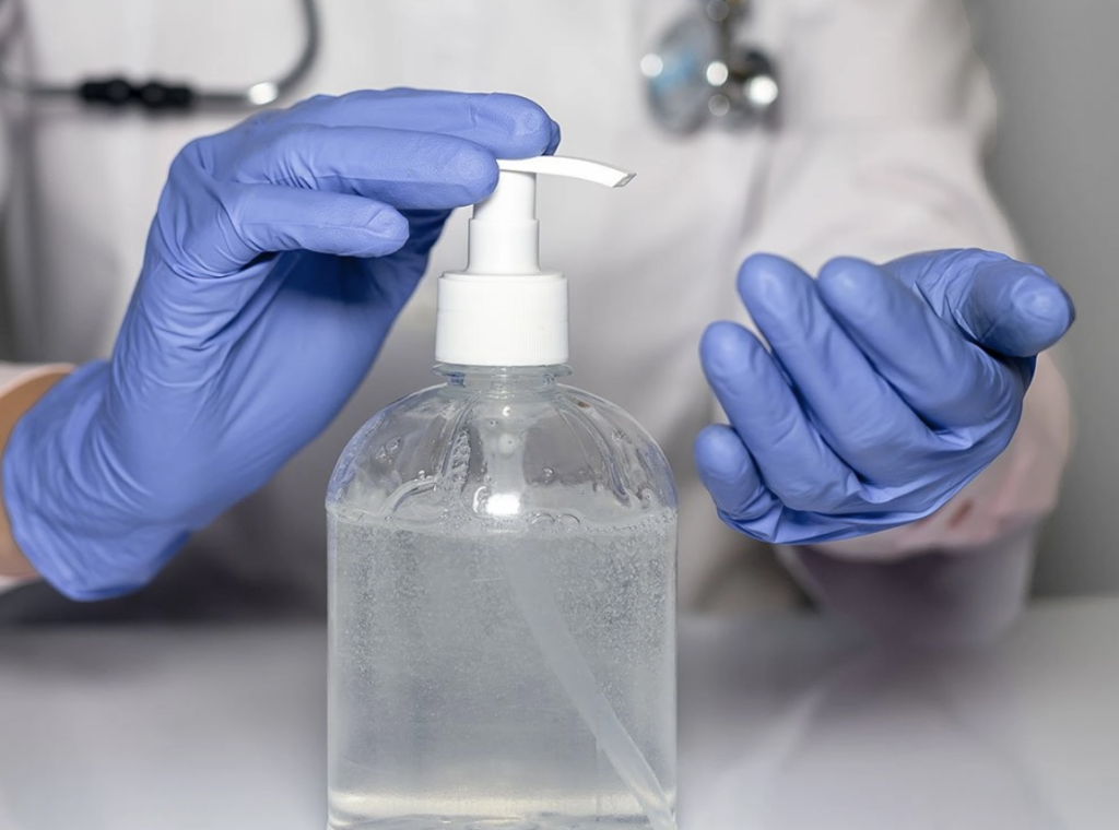 Healthcare professional using hand sanitizer